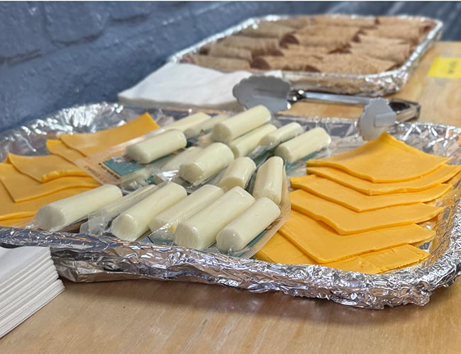Mozzarella String Cheese And Cheddar Slices. Platter of wrapped mozzarella string cheese sticks and sliced cheddar cheese.